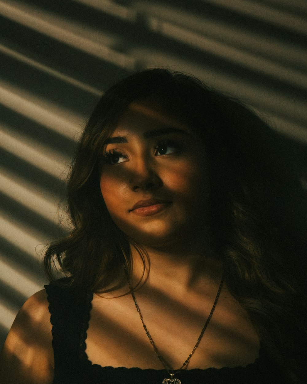 a woman in a black dress standing in front of a wall