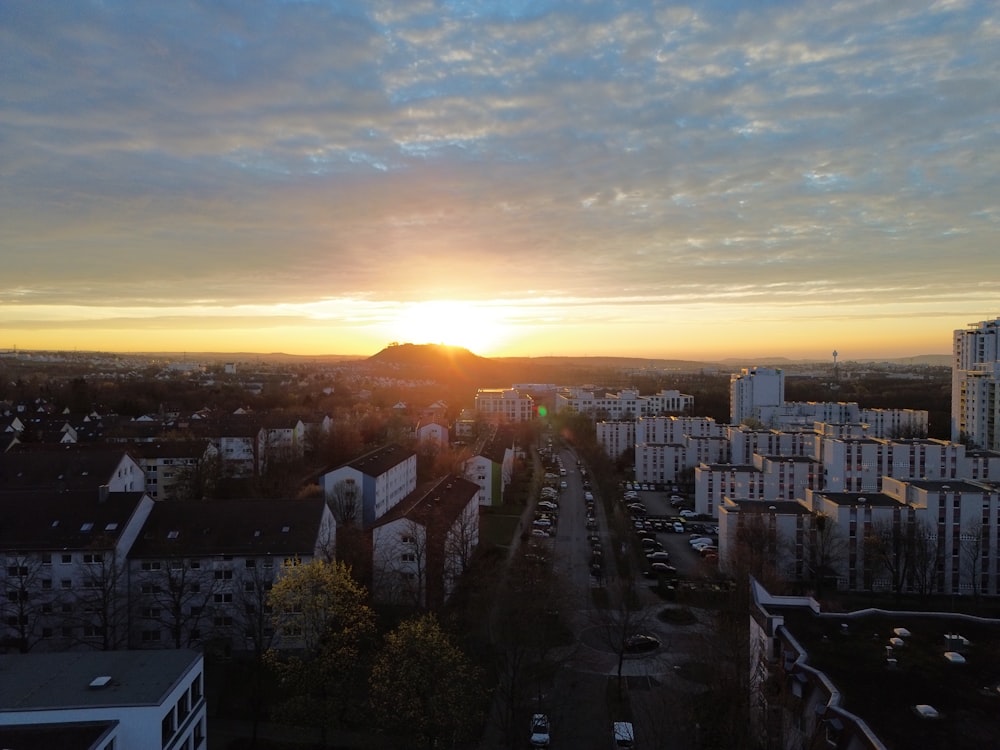 the sun is setting over a city with tall buildings