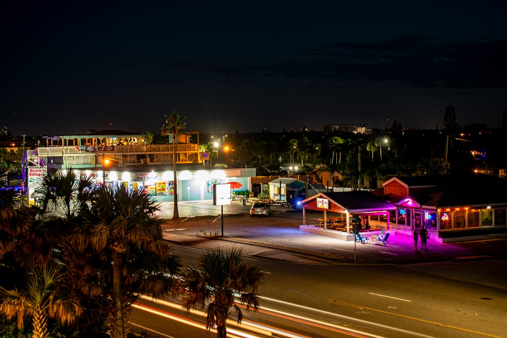 una calle de la ciudad por la noche con un edificio iluminado