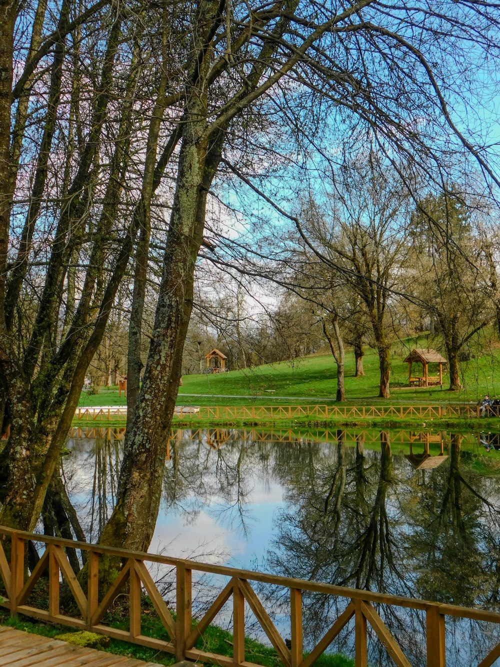 a wooden bridge over a small pond in a park