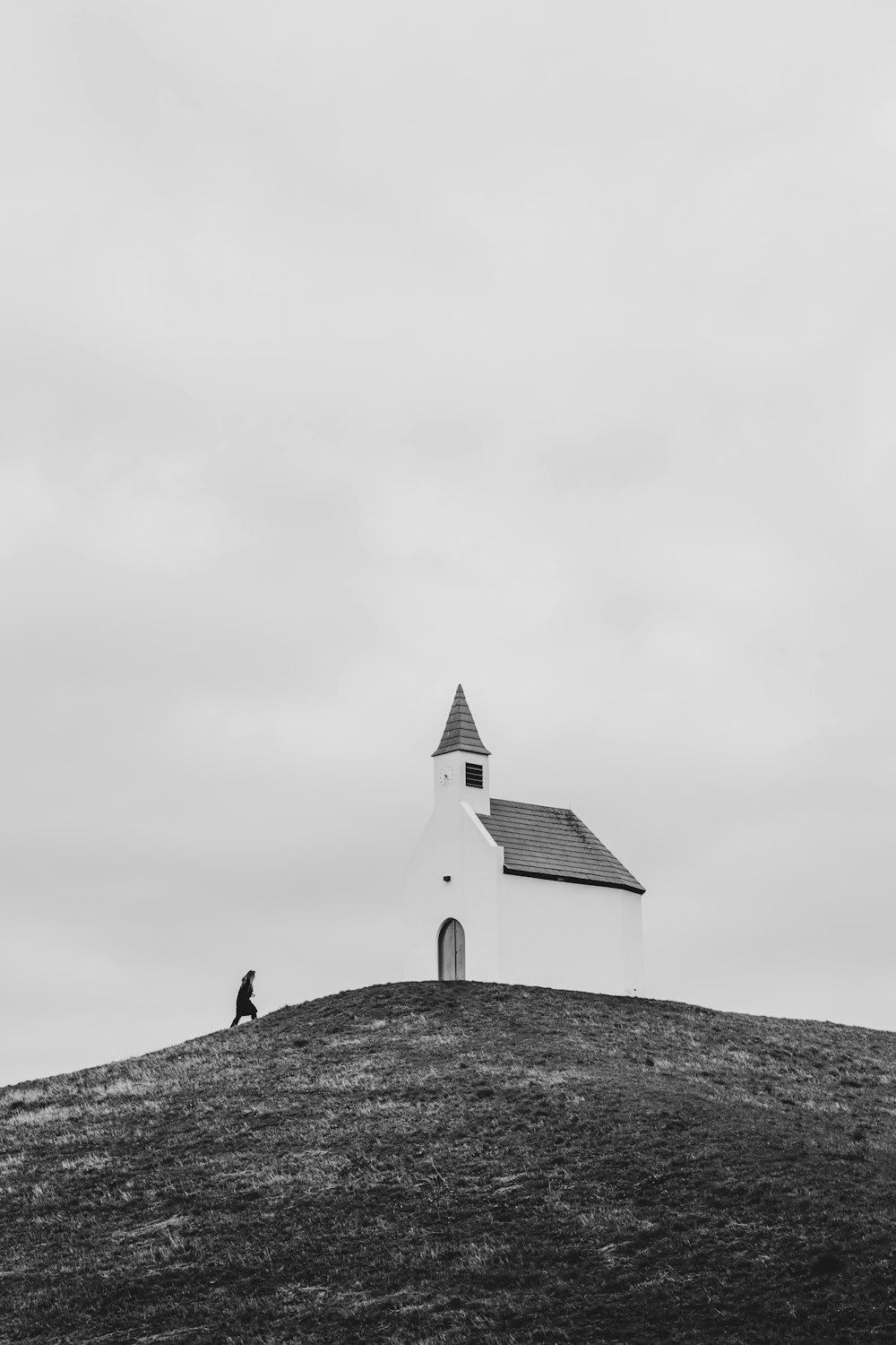 a black and white photo of a church on a hill