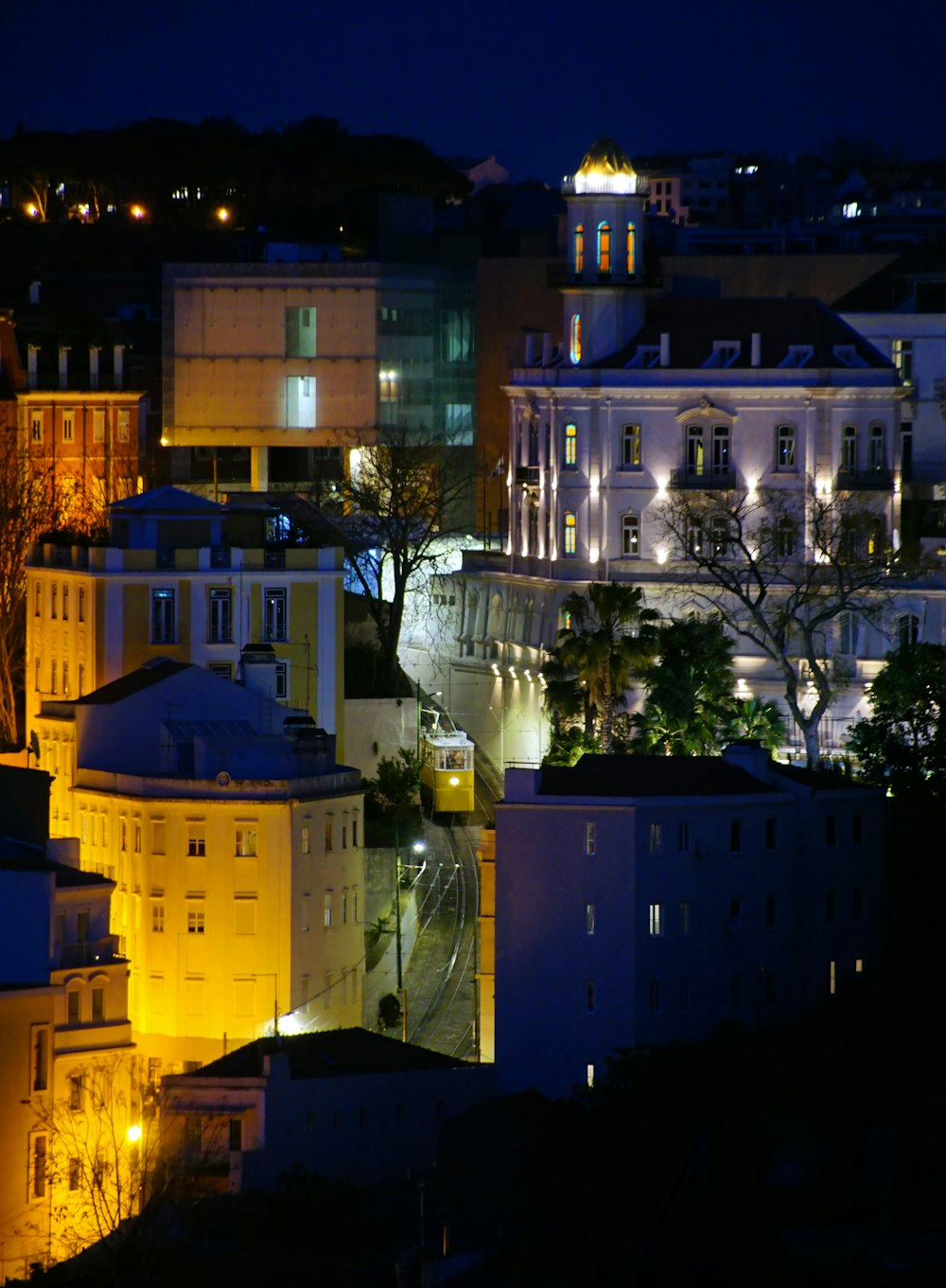 a view of a city at night from a hill