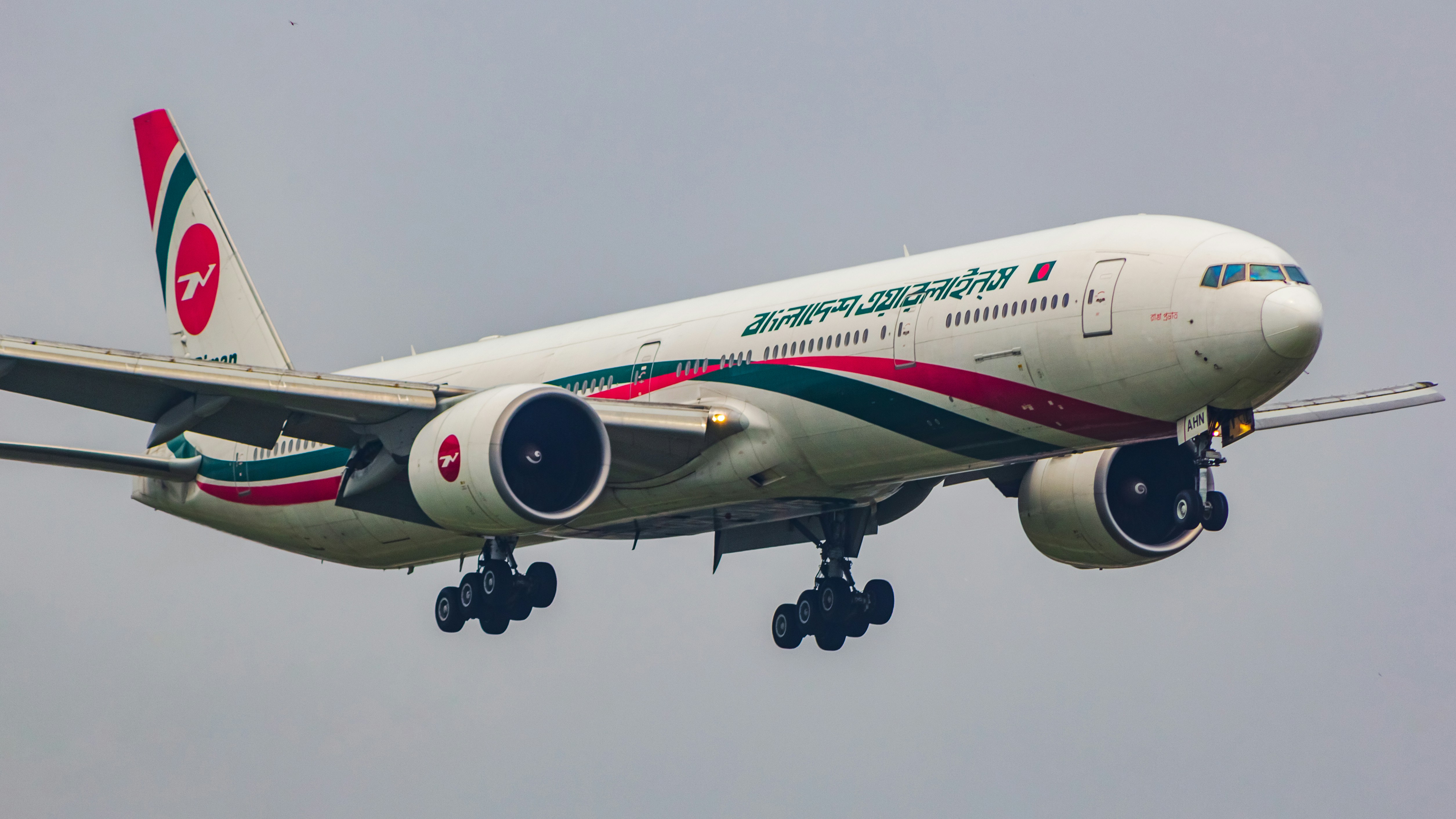 a large jetliner flying through a cloudy sky, Biman Bangladesh Airlines | Boeing 777-300ER
