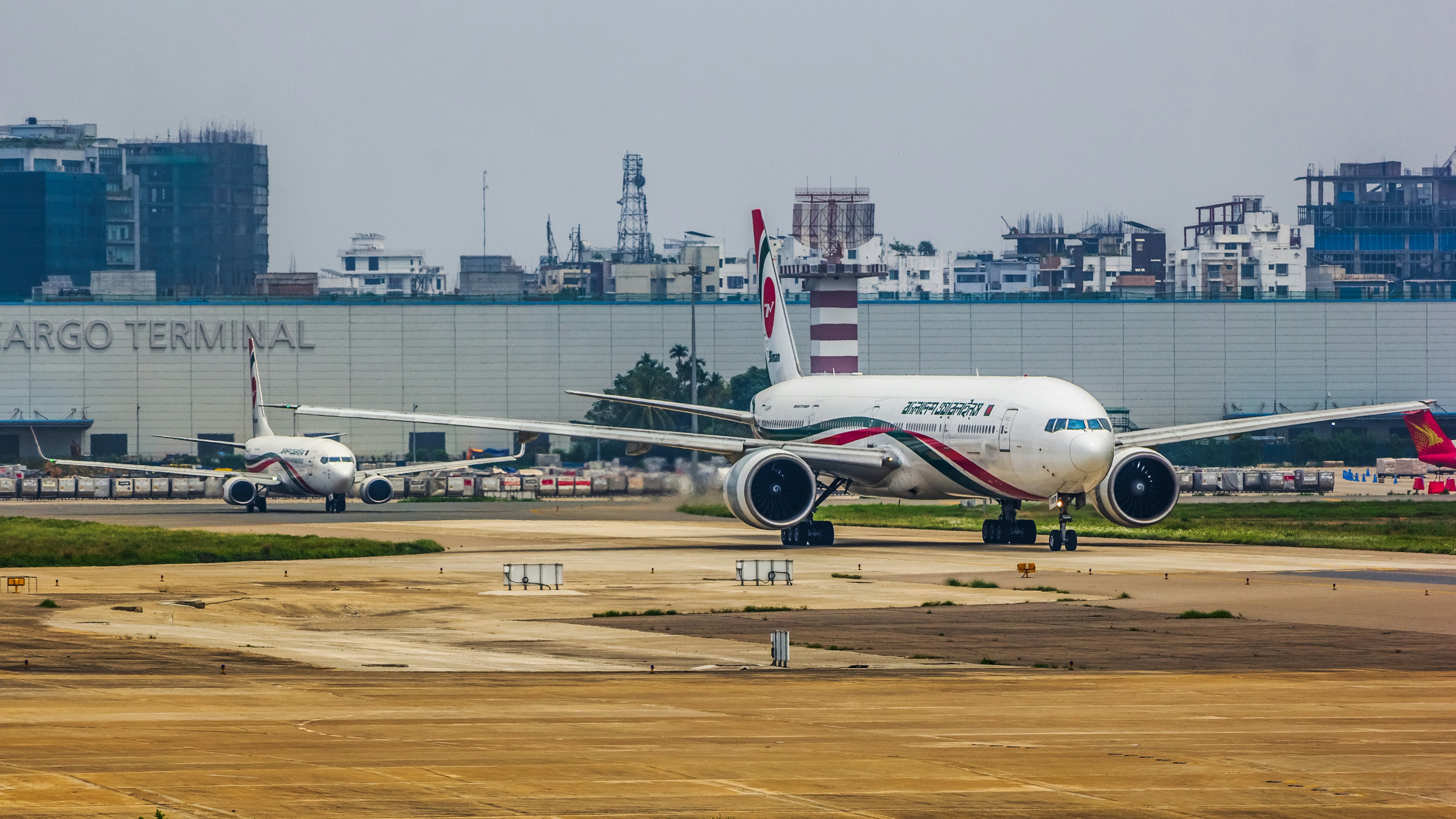 a large jetliner sitting on top of an airport tarmac, Biman Bangladesh Airlines | Boeing 777-300ER and Boeing 737-800