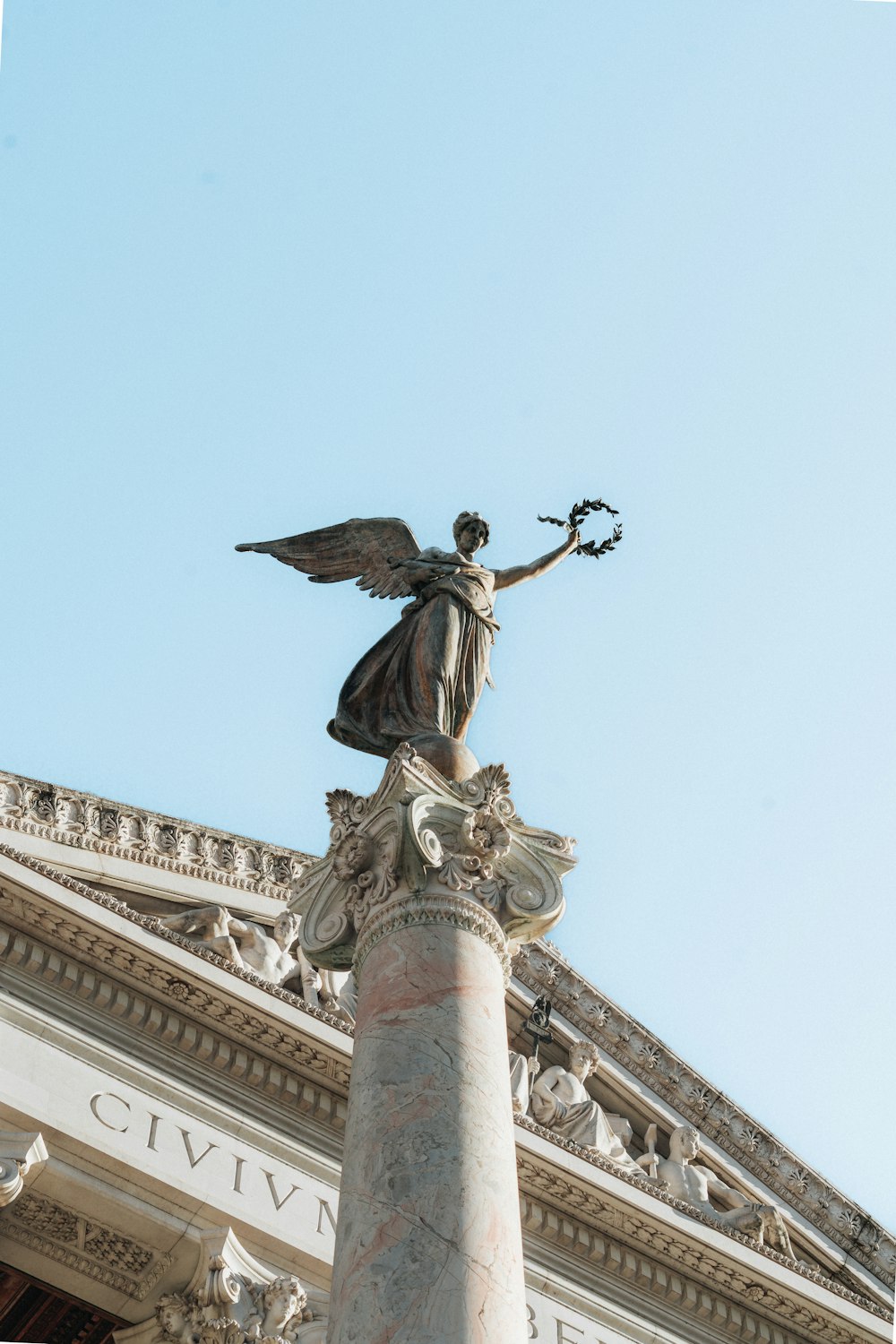 a statue on top of a pillar in front of a building