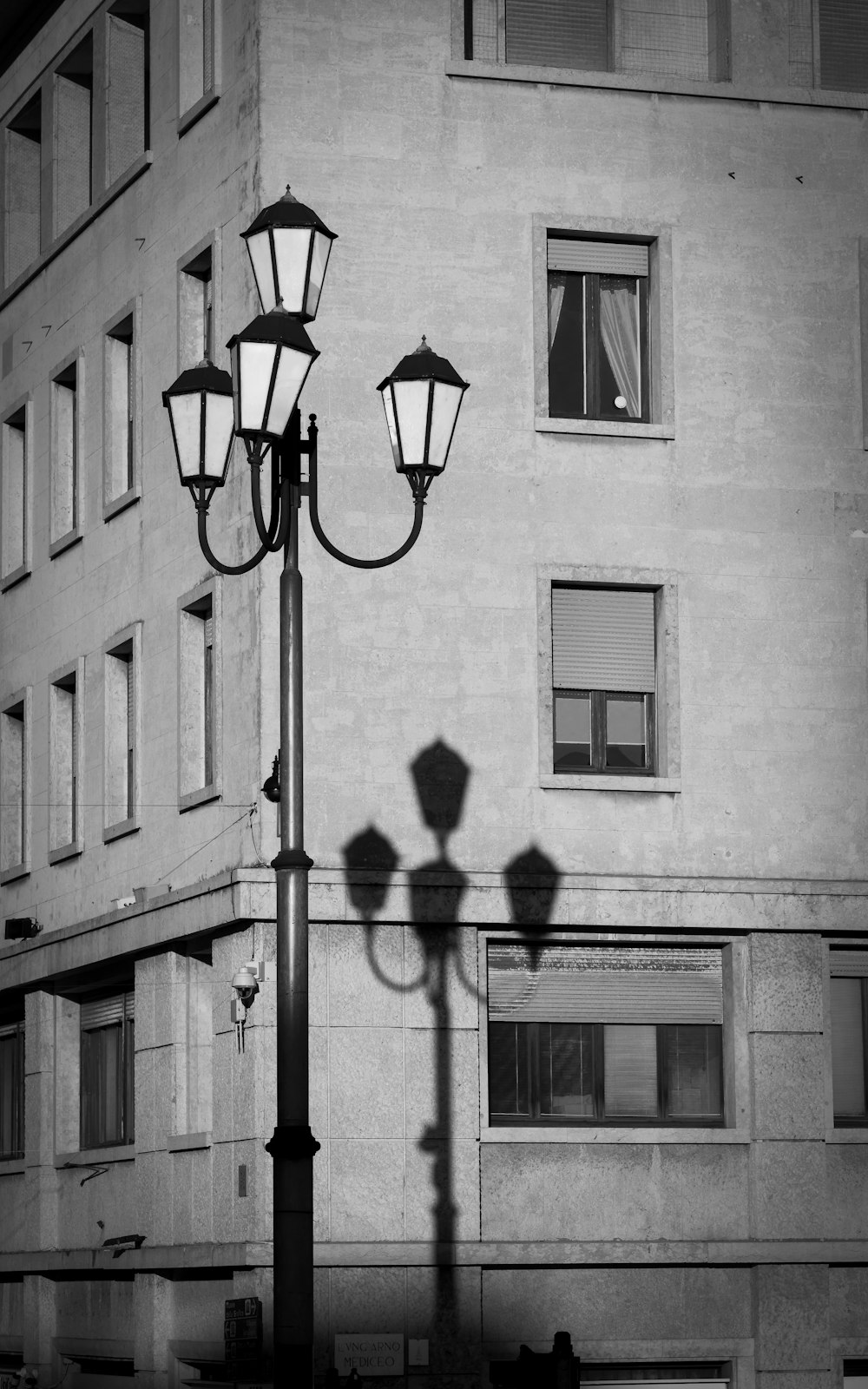 a black and white photo of a street light in front of a building