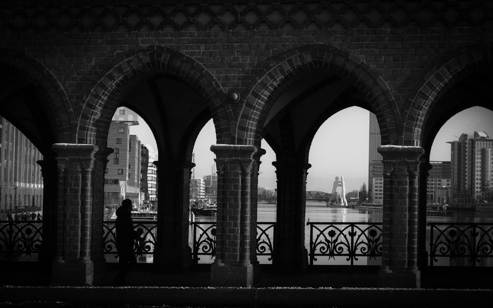 uma foto em preto e branco de uma pessoa olhando para uma cidade