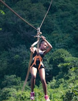 a woman on a zip line in the forest