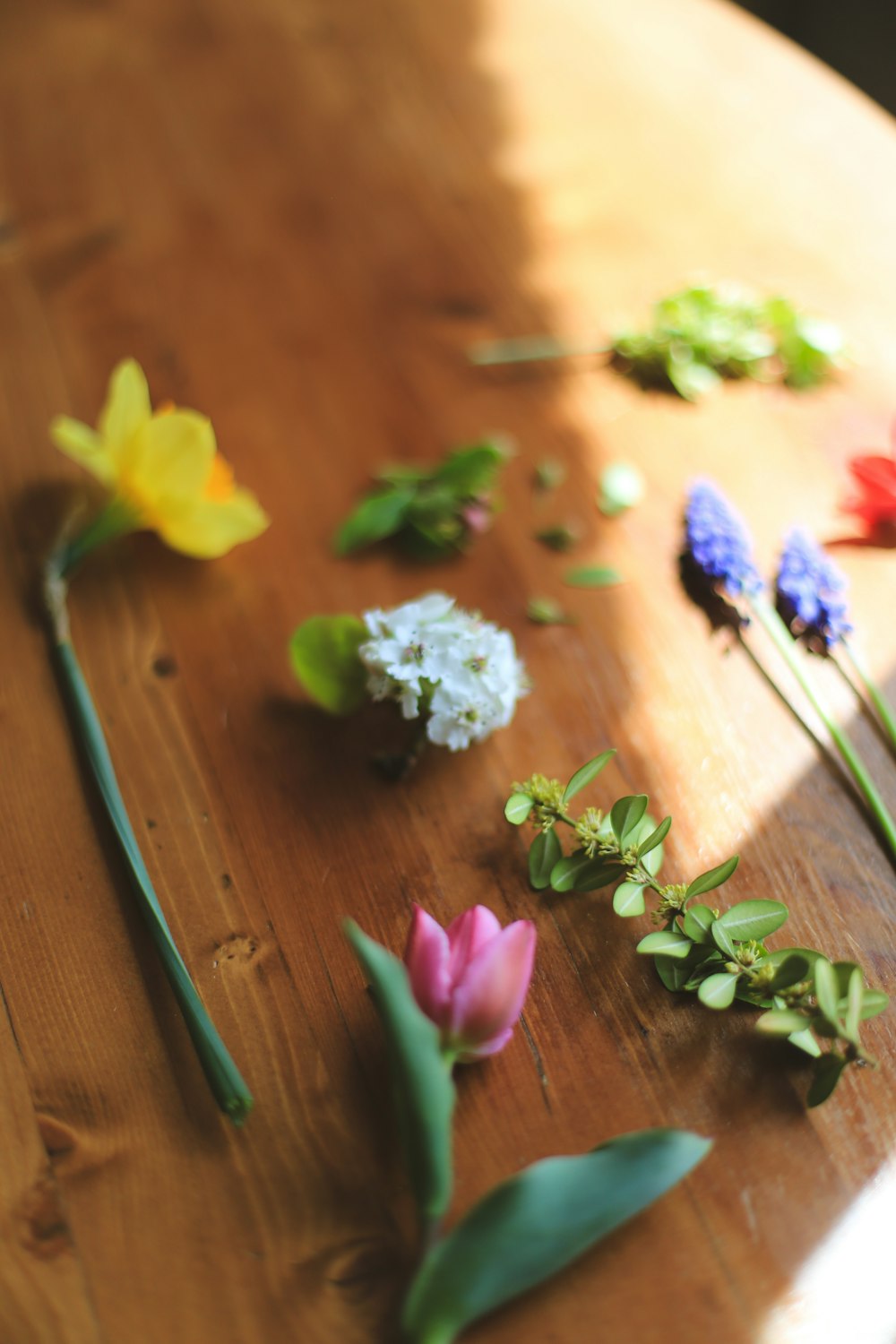 a wooden table topped with different types of flowers