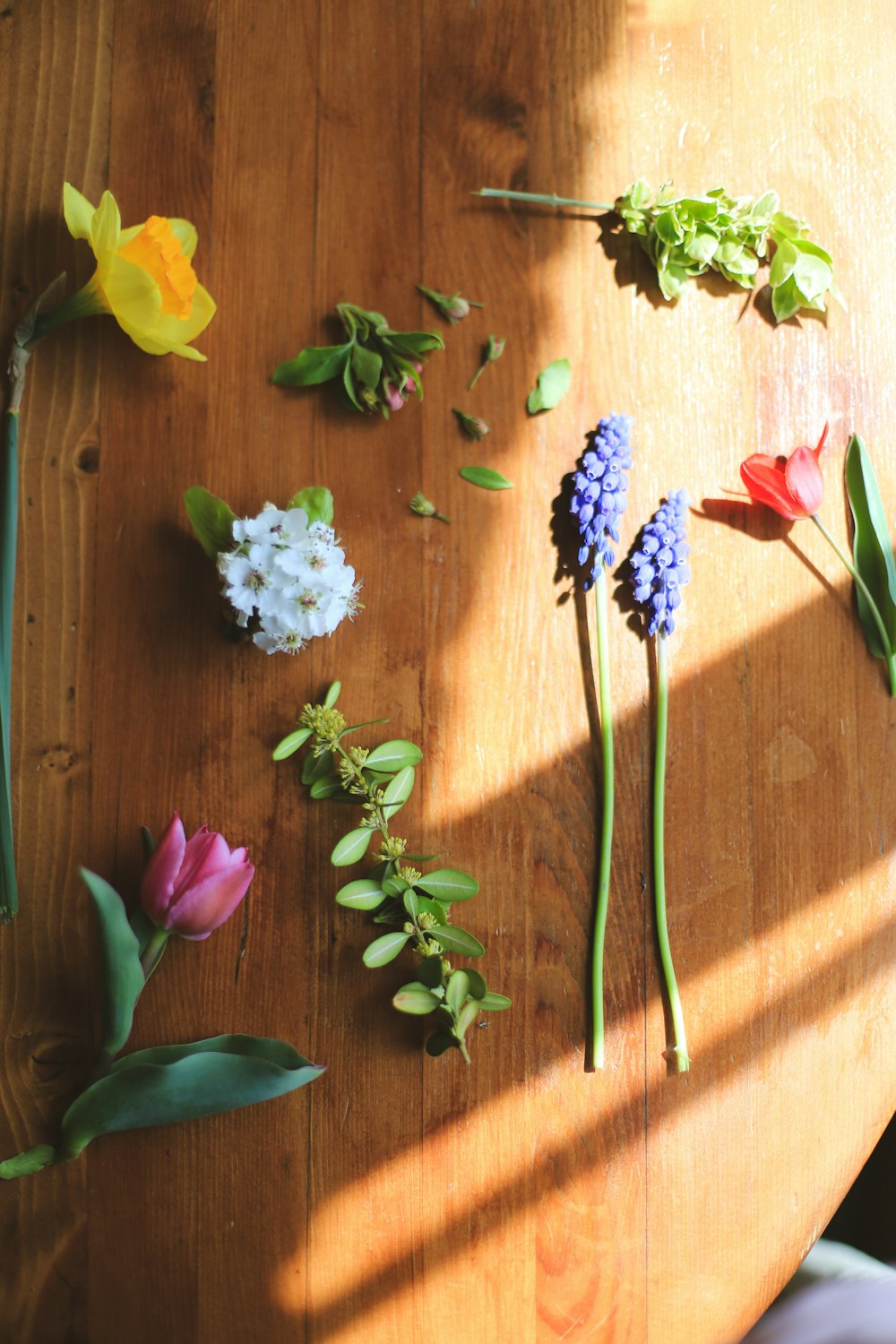 a wooden table topped with different types of flowers