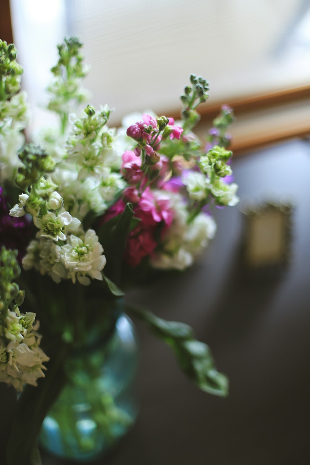 un jarrón lleno de flores encima de una mesa