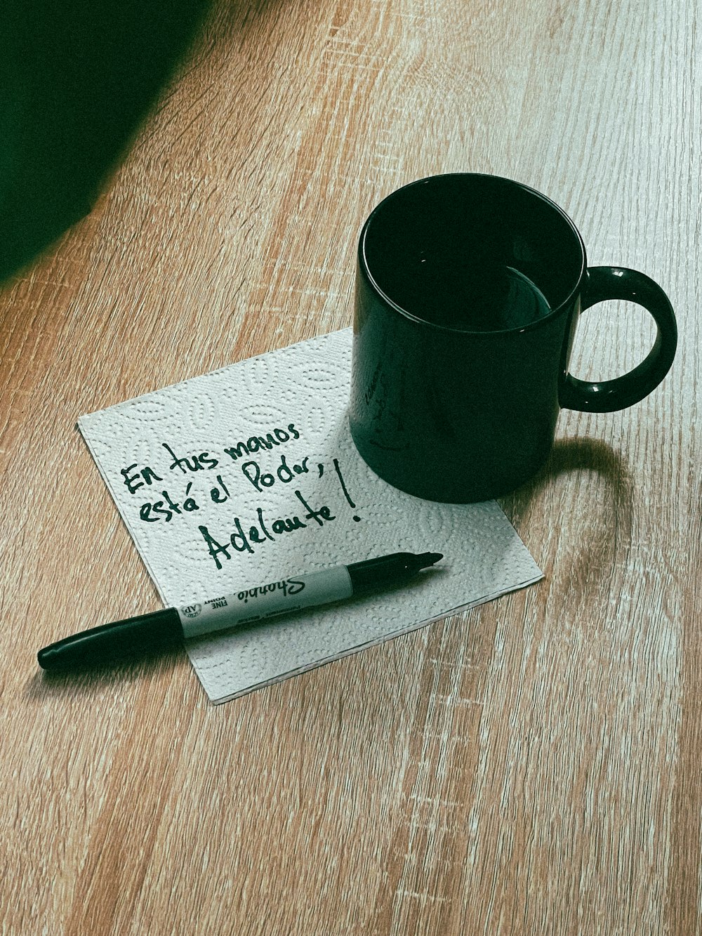 a cup of coffee and a note on a table