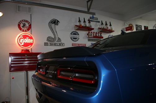a blue car parked in a garage next to a red sign