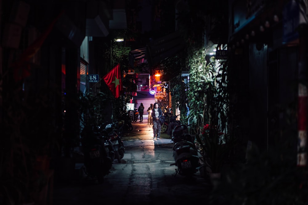 a dark alley at night with motorcycles parked on the side of the street