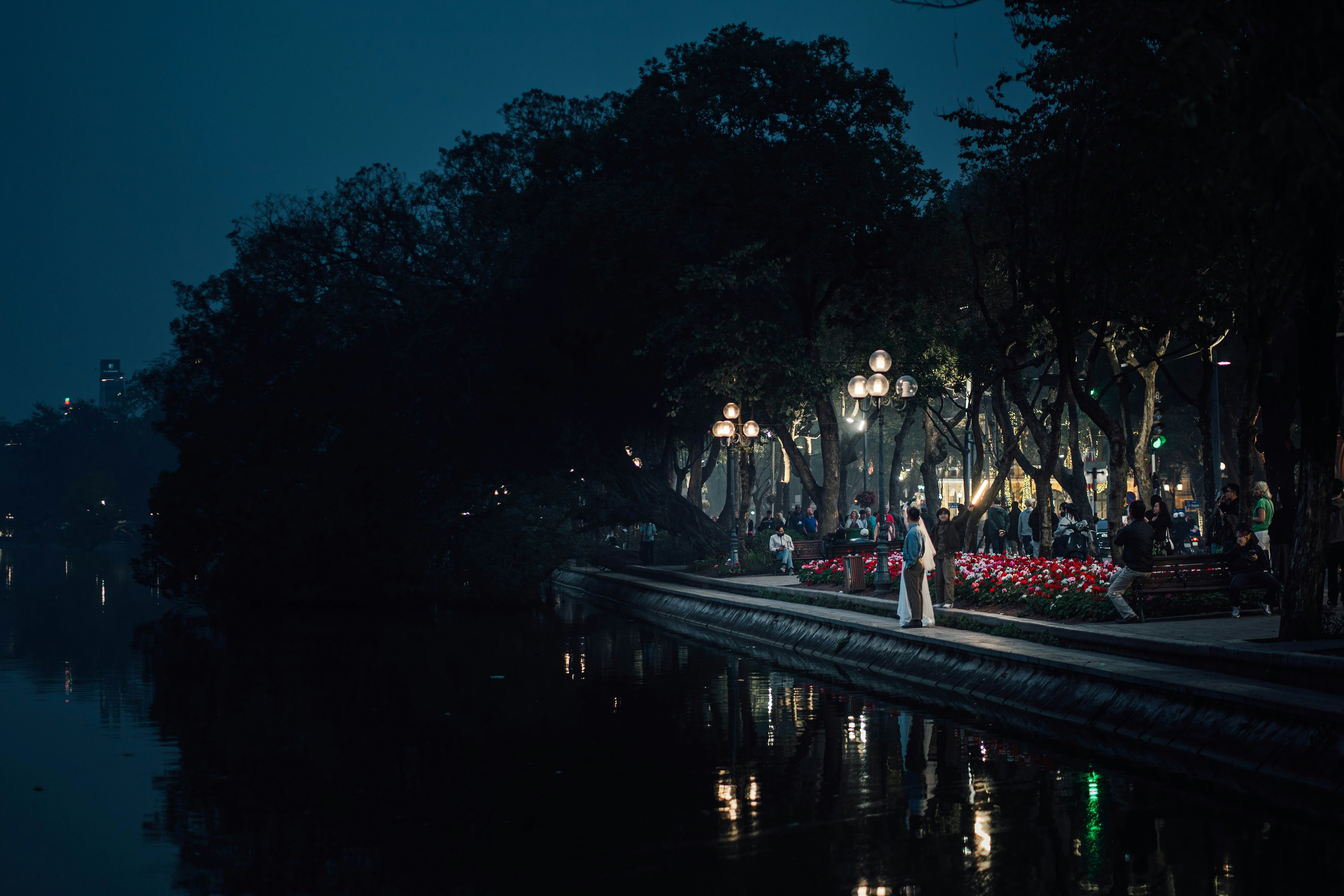 a person standing on the edge of a body of water at night
