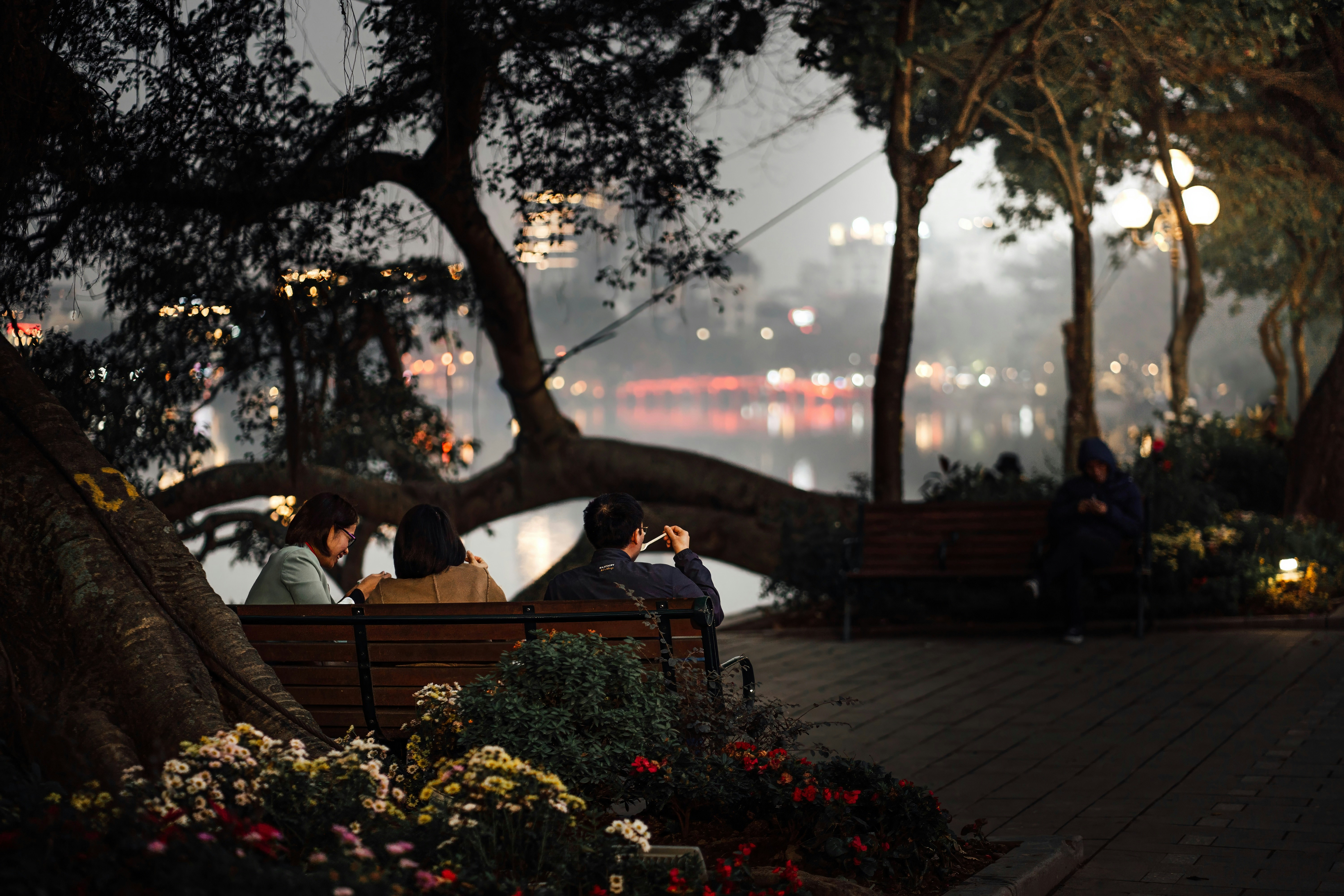 a group of people sitting on top of a wooden bench