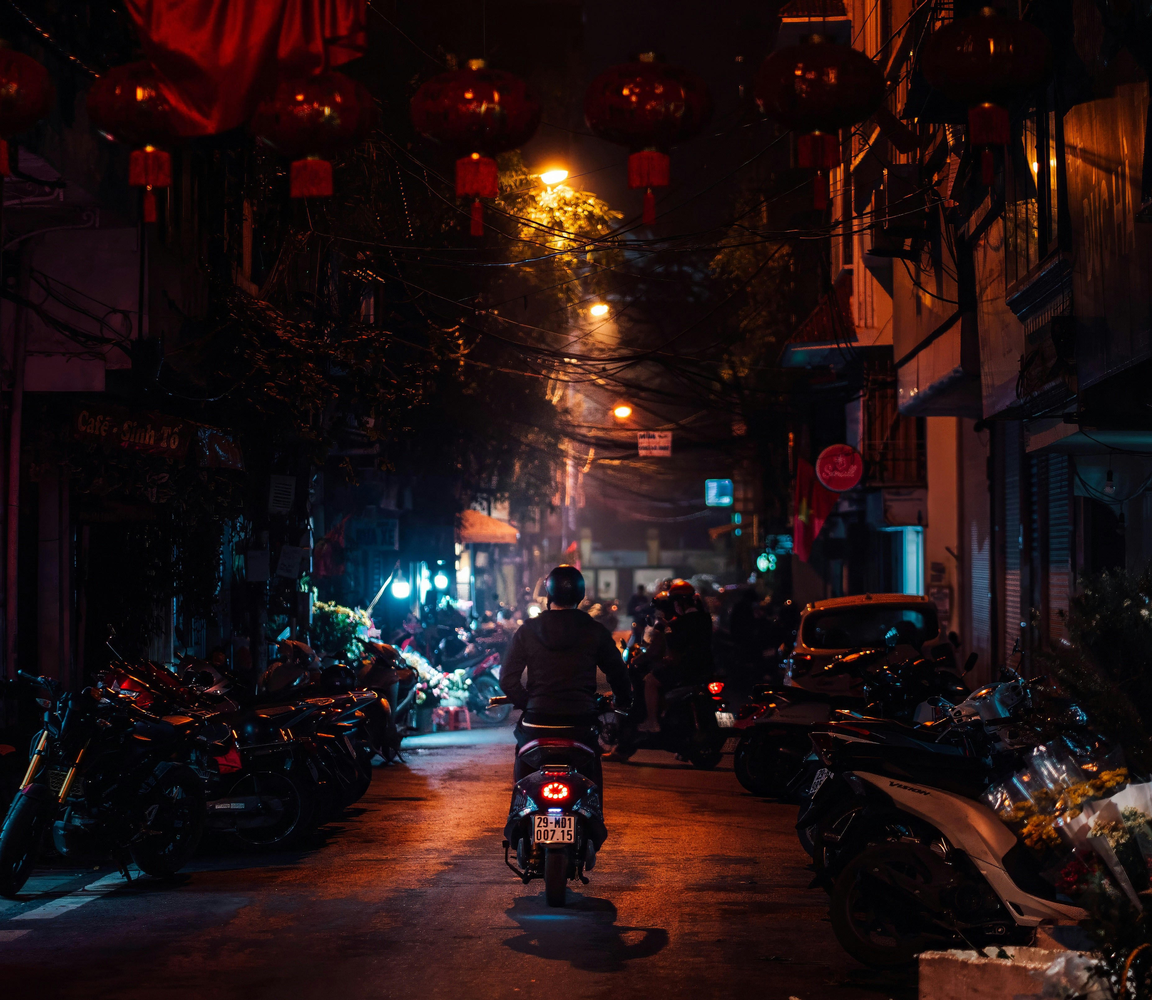 a man riding a motorcycle down a street at night