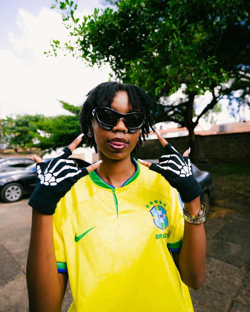 a woman wearing a yellow shirt and black gloves