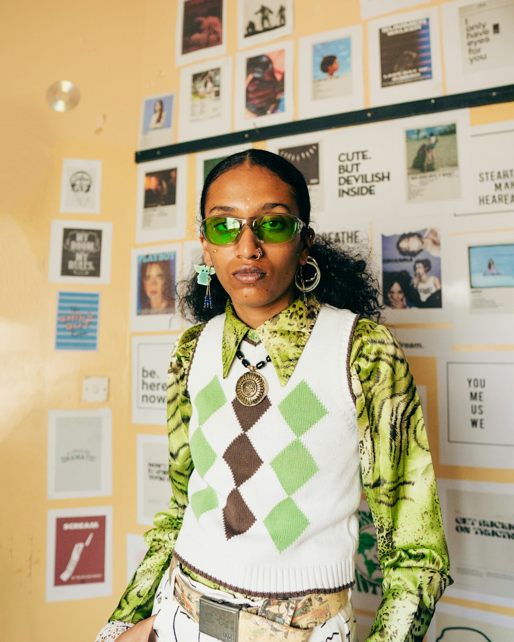 a woman wearing a sweater and green sunglasses