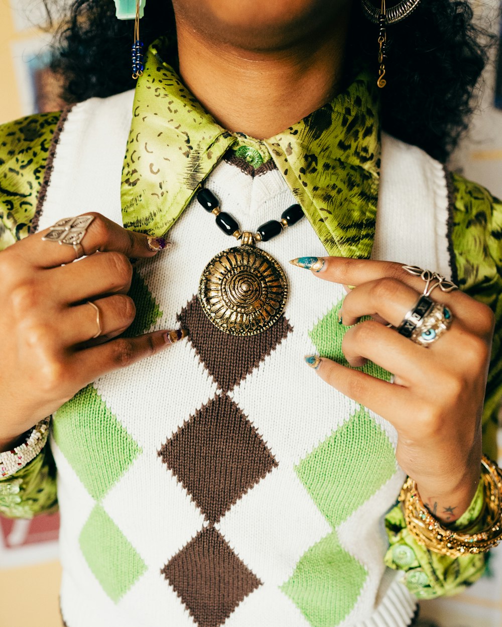 a woman wearing a green and brown argyle sweater