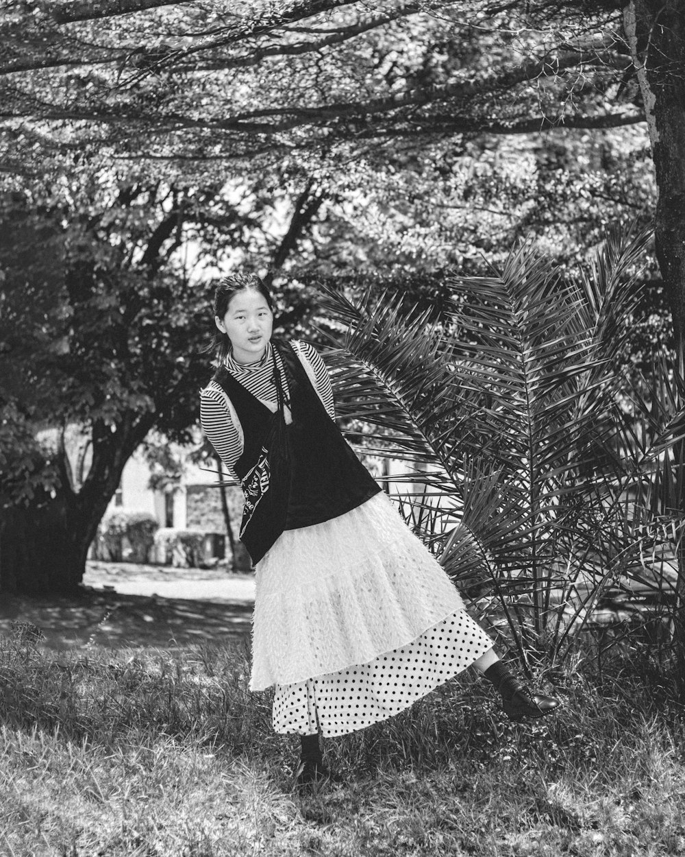 a woman in a dress is standing in the grass