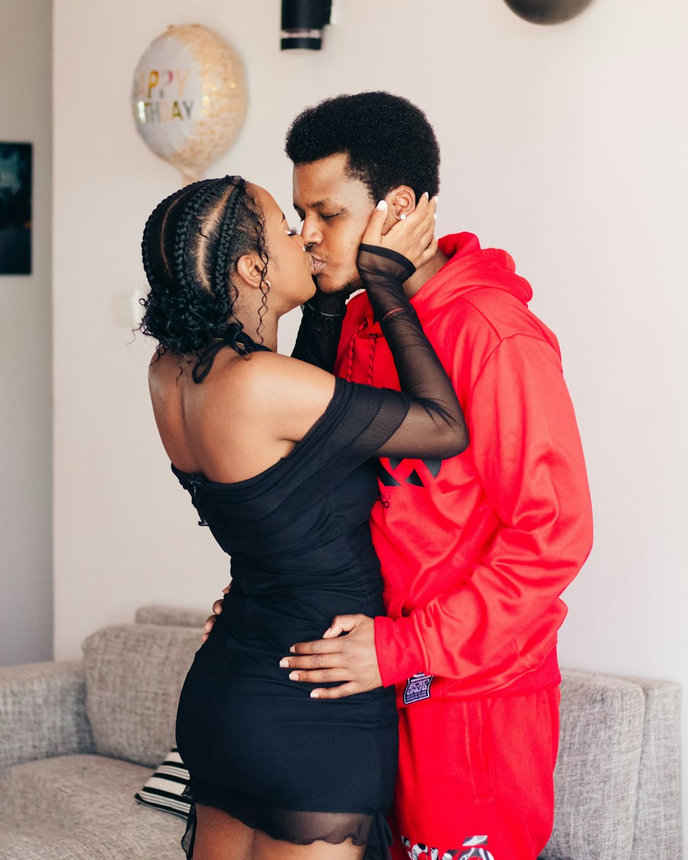 a man and a woman kissing in a living room