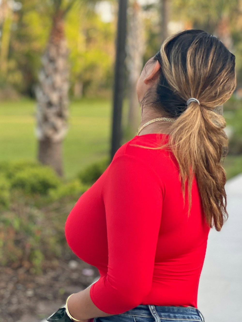 a woman in a red top is holding a cell phone