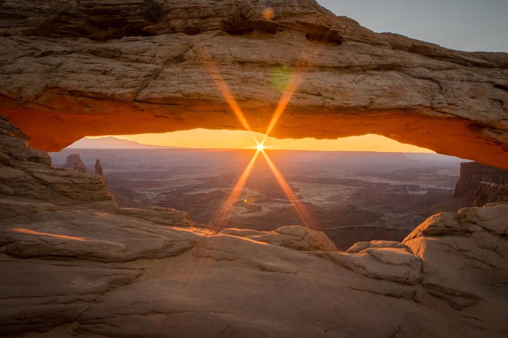 the sun is setting over a rocky landscape