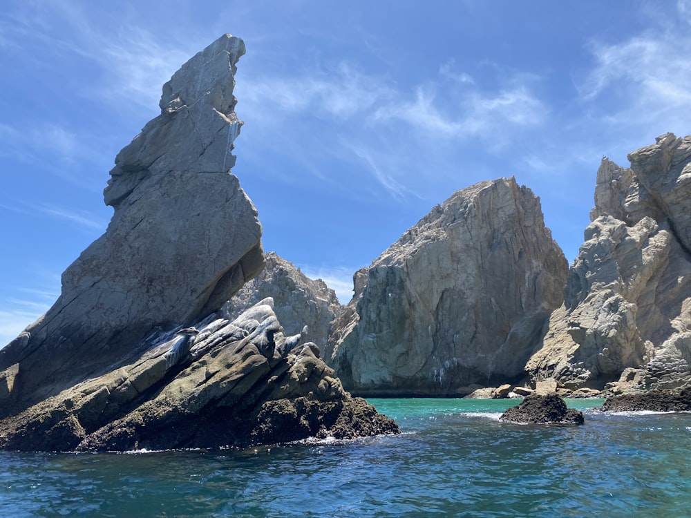 a large rock formation in the middle of a body of water