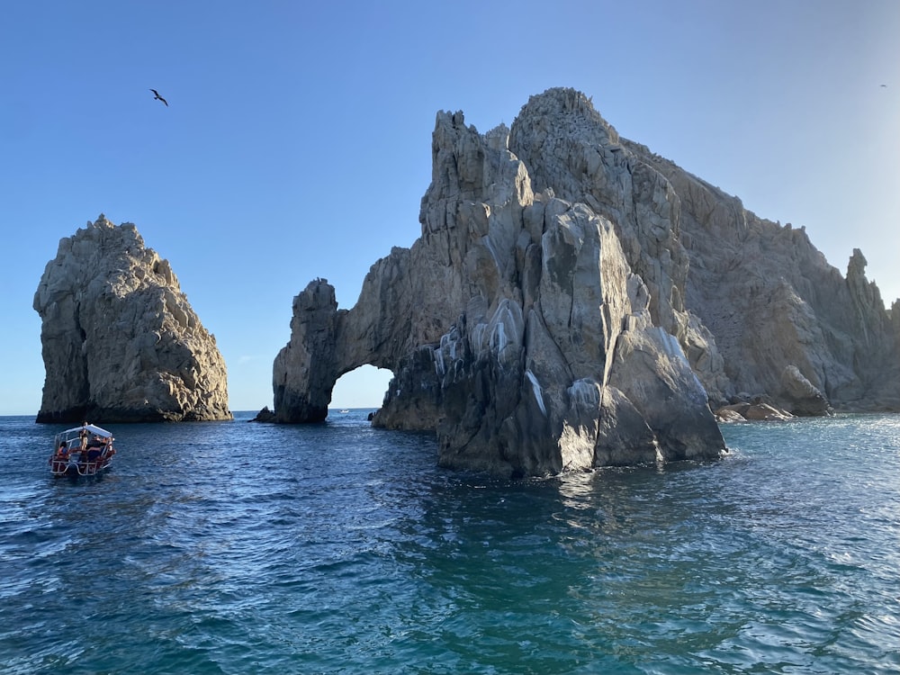 a boat in the water near a large rock formation