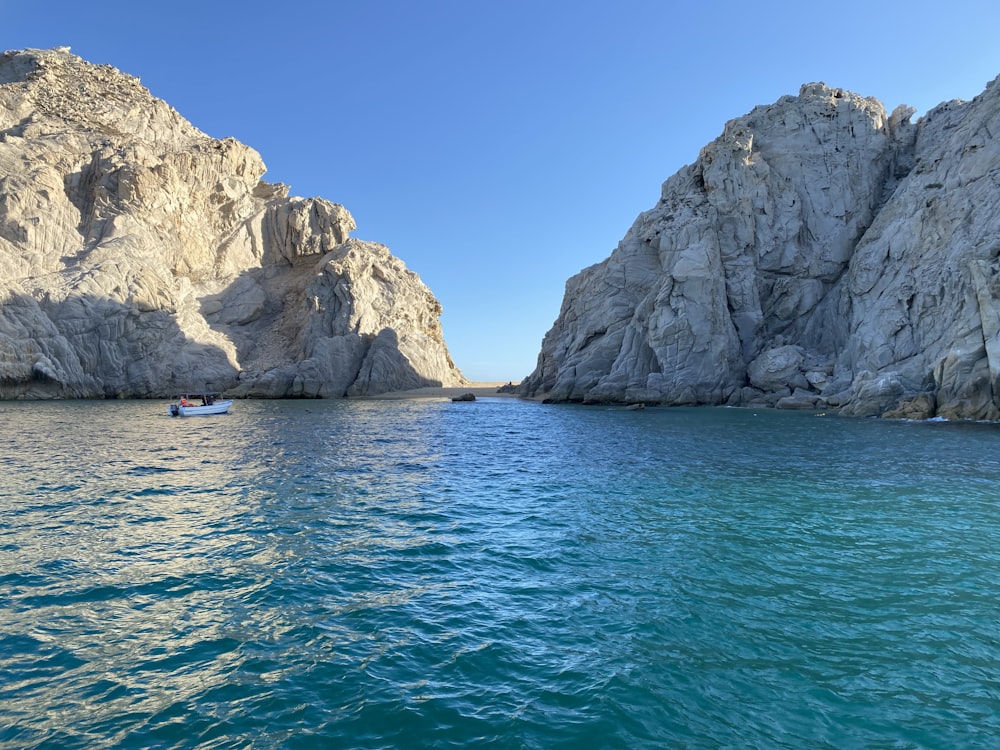 a boat in a body of water near some rocks