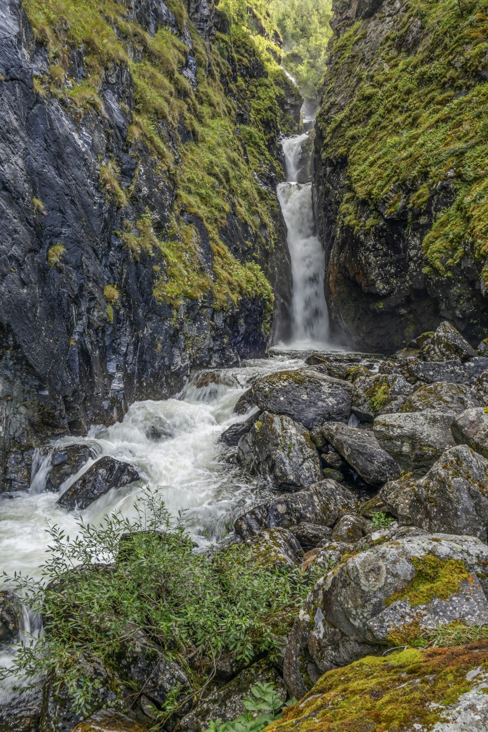 a small waterfall in the middle of a rocky area