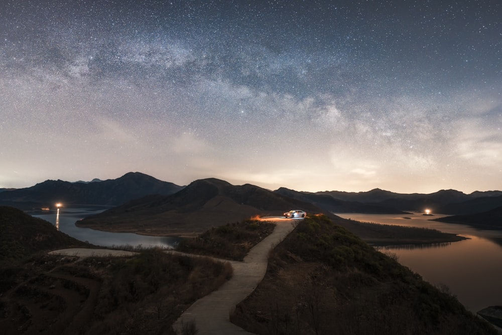 a night time view of a lake and mountains