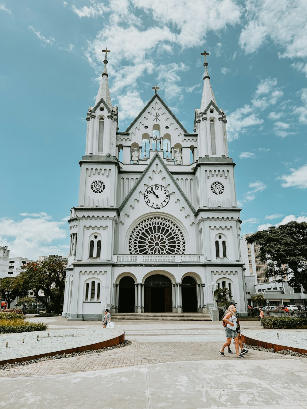 two people walking in front of a large white church