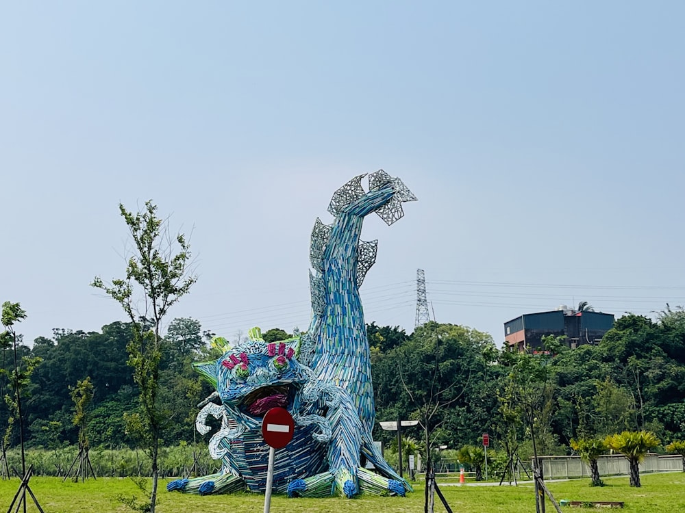 a large blue dragon sculpture in the middle of a field