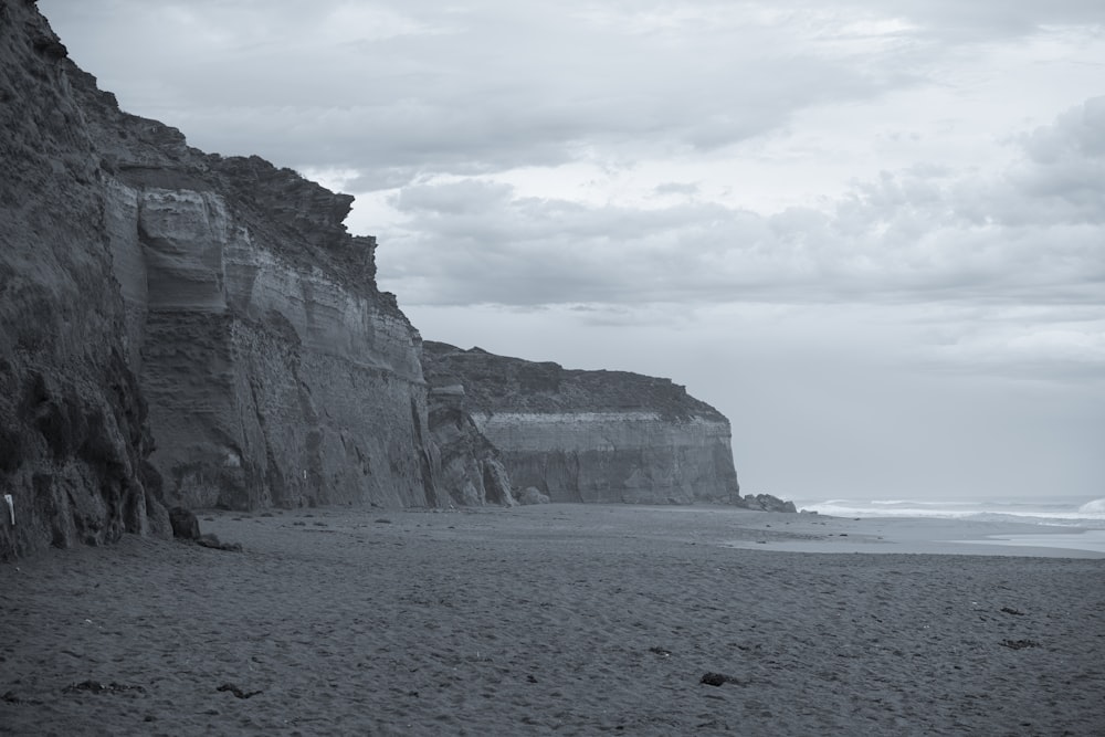 a black and white photo of a beach and cliffs