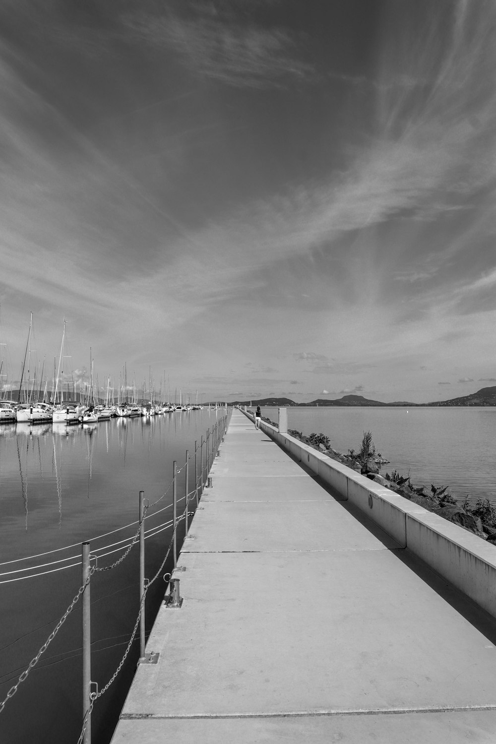 a black and white photo of a long dock