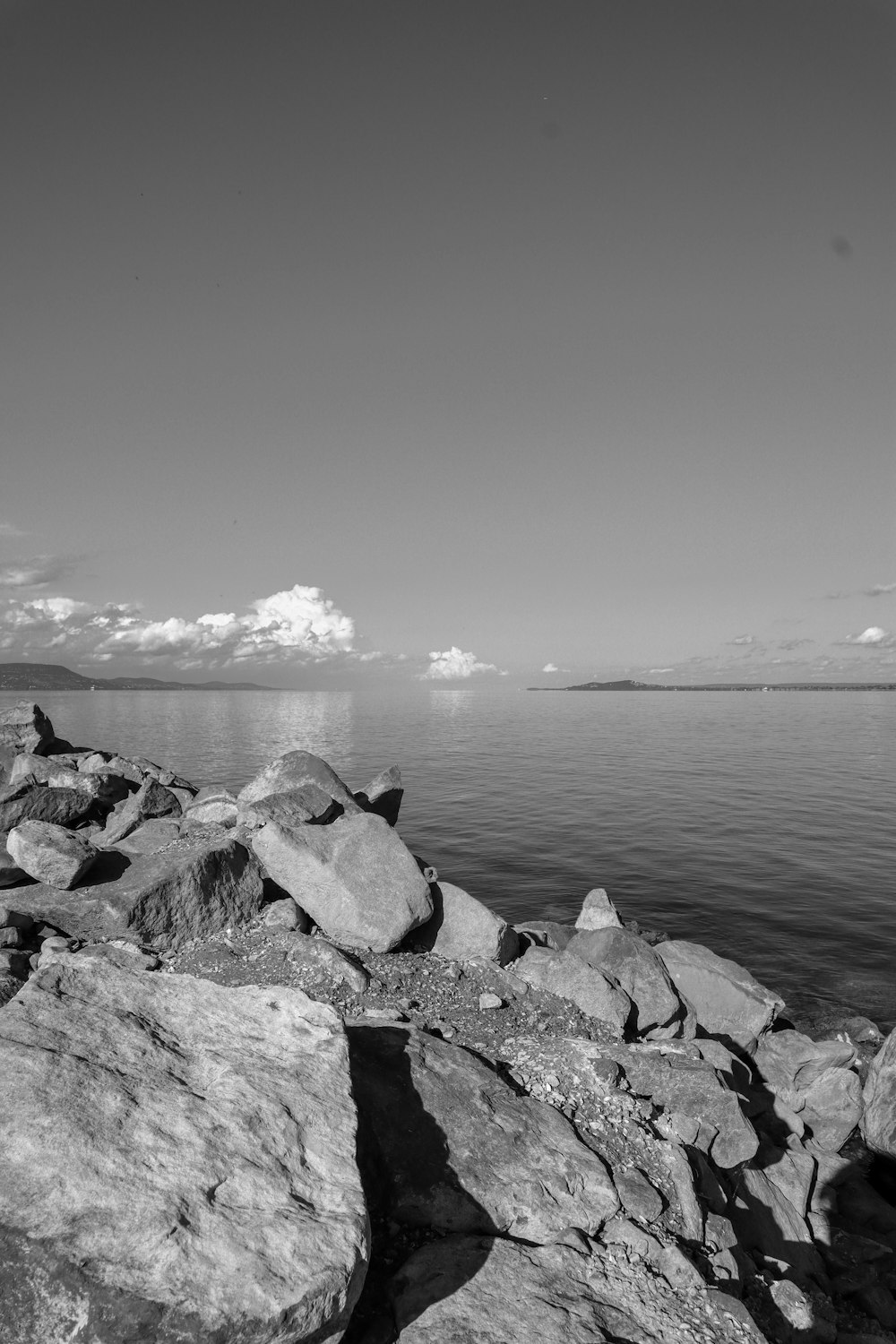 a black and white photo of rocks and water