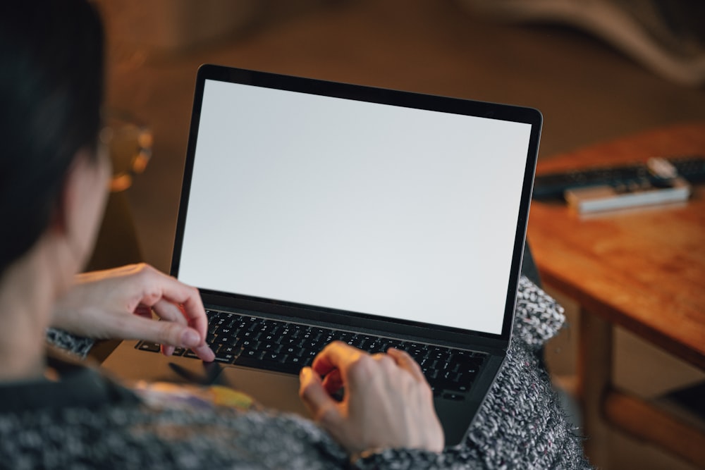 a woman sitting on a couch using a laptop computer