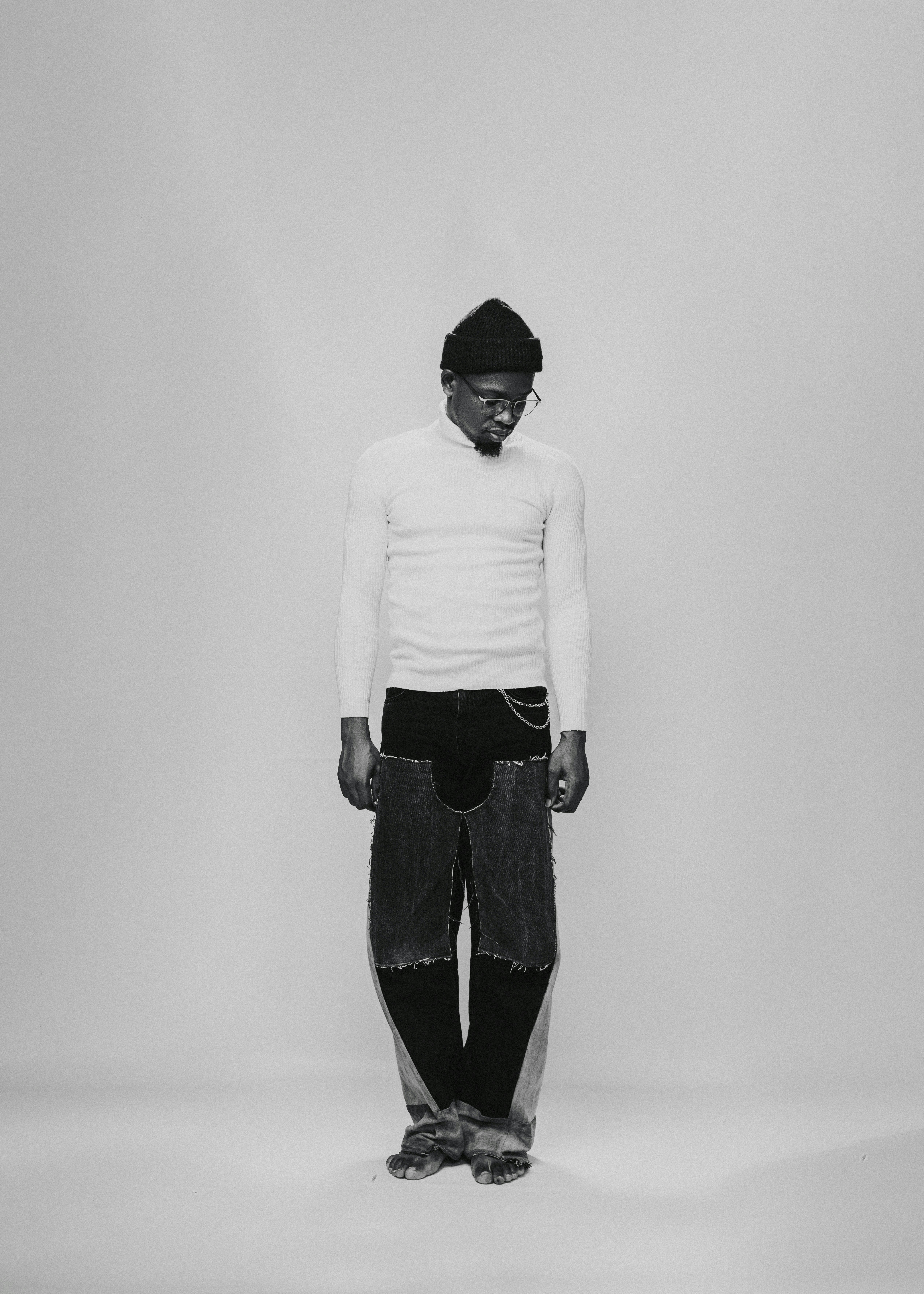 a black and white photo of a man wearing a hat