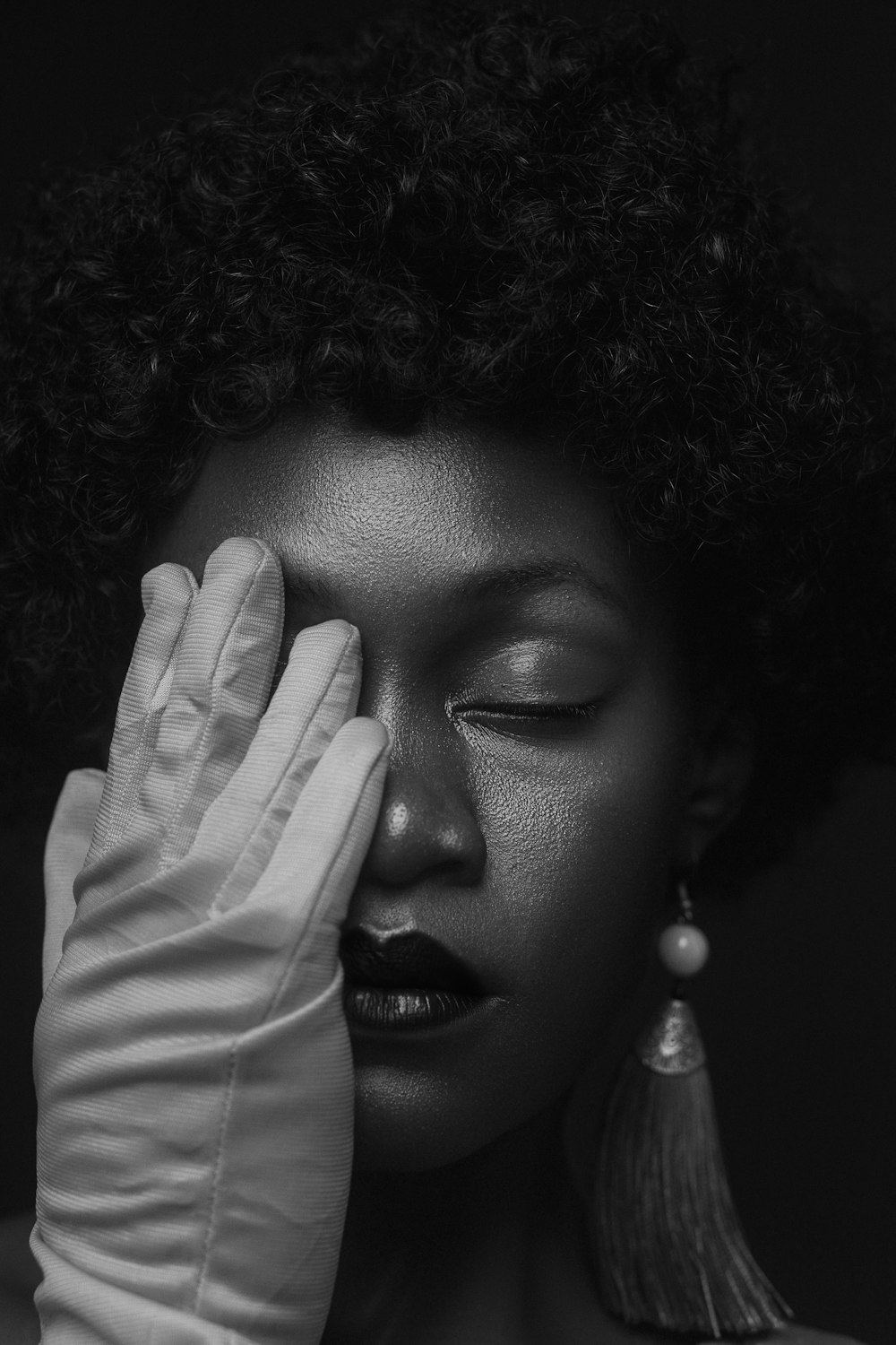 a woman wearing gloves covers her face with her hands