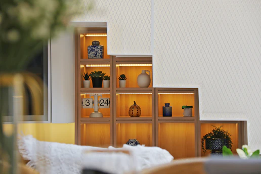 a living room with a book shelf filled with vases