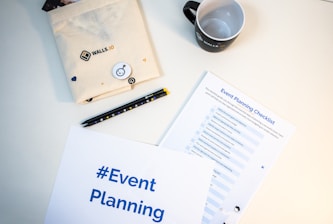 a table with a coffee cup, notepad, pen, and envelope
