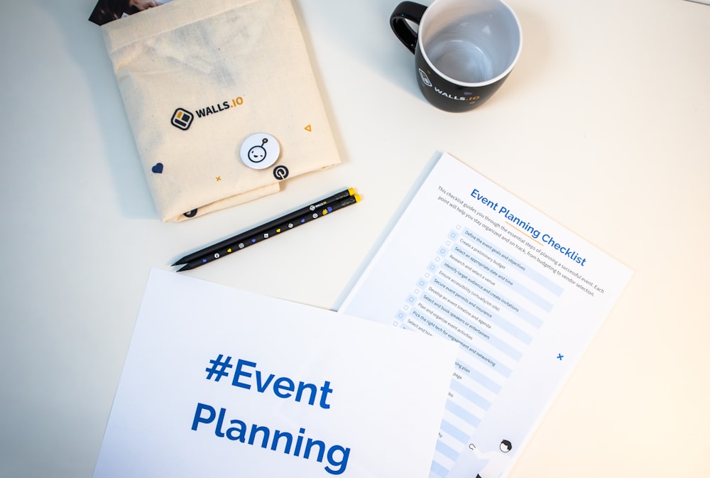 a table with a coffee cup, notepad, pen, and envelope