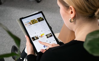 a woman sitting on the floor looking at a tablet