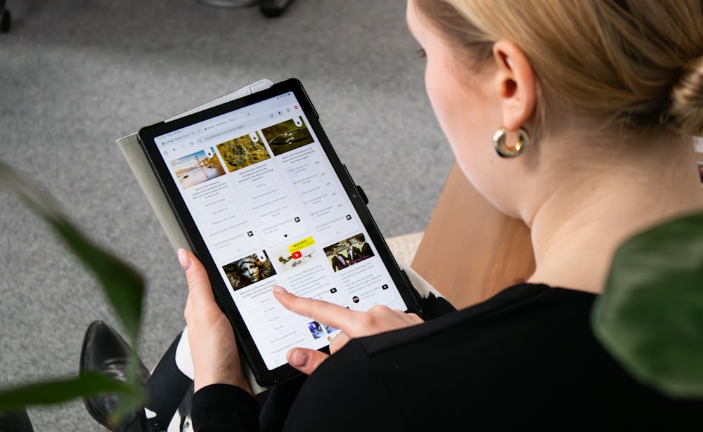 a woman sitting on the floor looking at a tablet