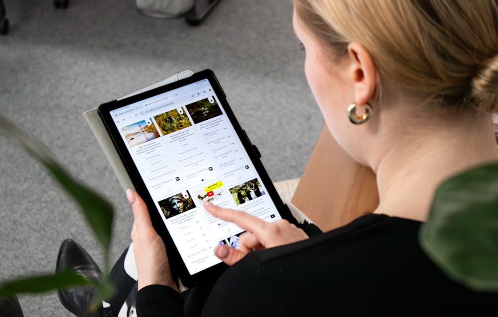 a woman sitting on the floor looking at a tablet