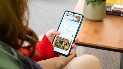 a woman sitting on a couch holding a cell phone