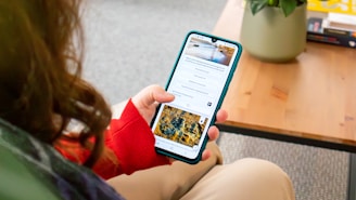 a woman sitting on a couch holding a cell phone