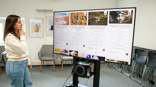 a woman standing in front of a large poster